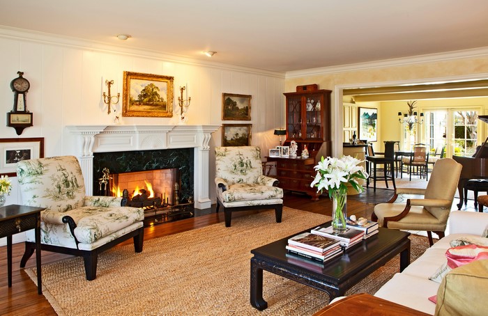 Living room with fireplace, armchairs, and dining area