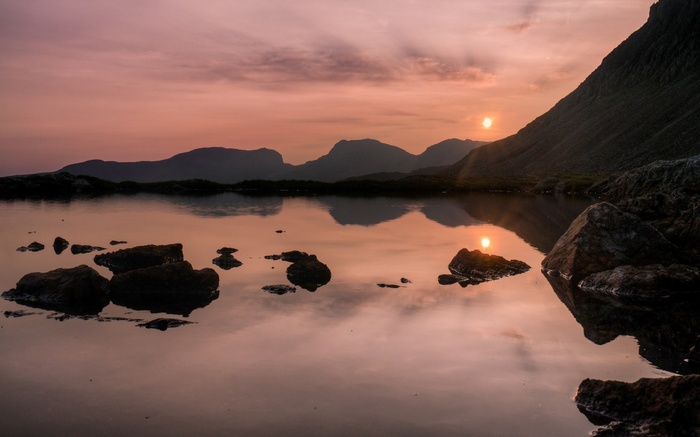 Sunset over a mountain lake with reflections