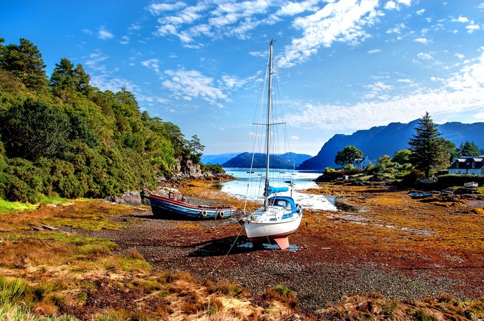 Boats on a shore in Scotland with mountains