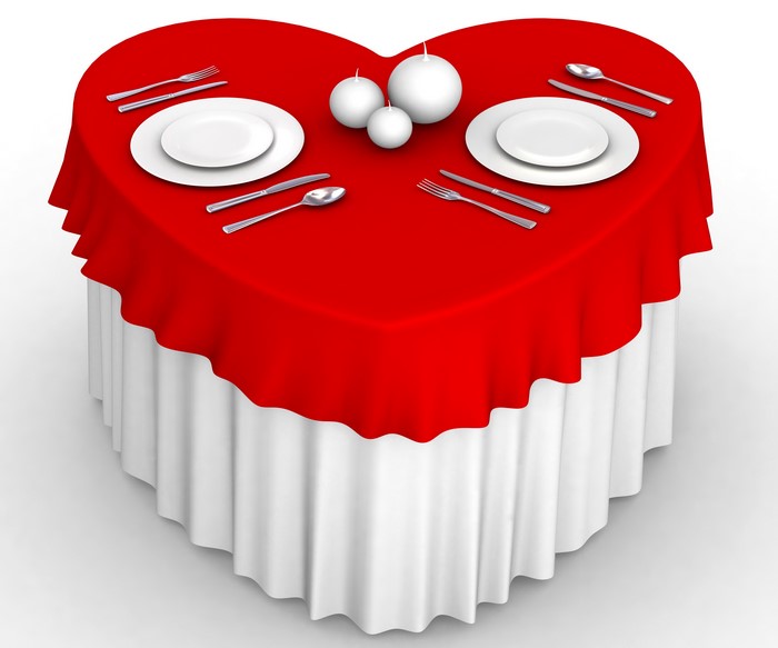 Heart-shaped table set for two with candles