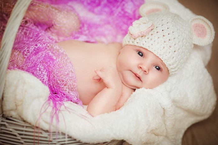 Baby in a mouse hat in a basket
