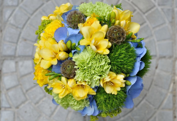 Bouquet of yellow freesia, blue hydrangea, and green carnations