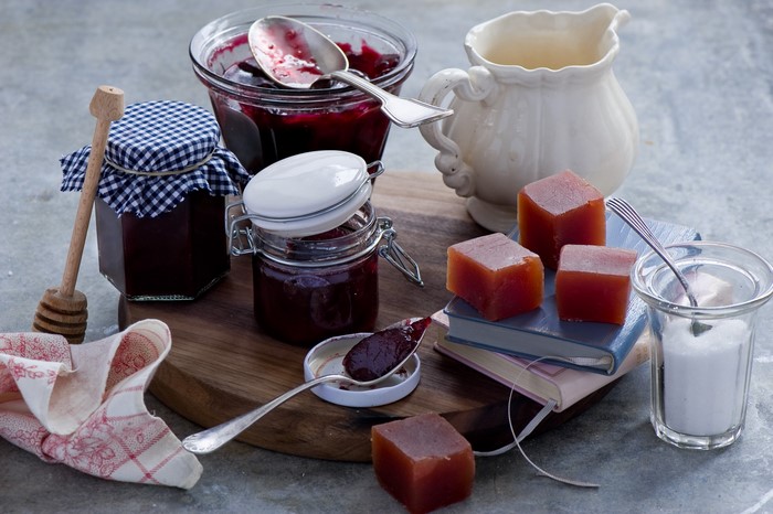 Jars of jam, quince paste, and sugar with a pitcher