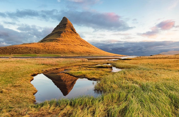 Kirkjufell mountain reflected in a stream under clouds