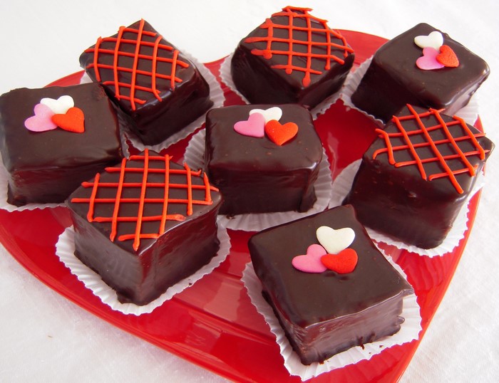 Chocolate petit fours with heart decorations on a heart-shaped tray