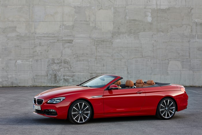 Red BMW M6 Convertible parked in front of a concrete wall