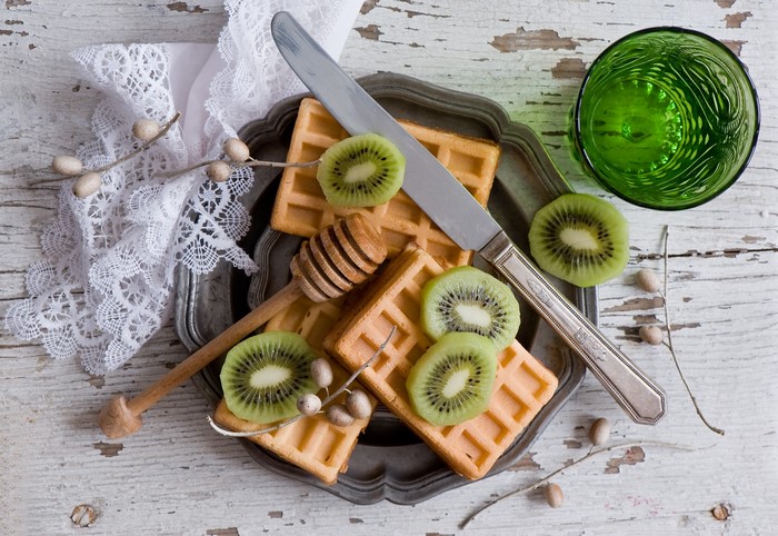 Waffles with kiwi and a knife on a tray
