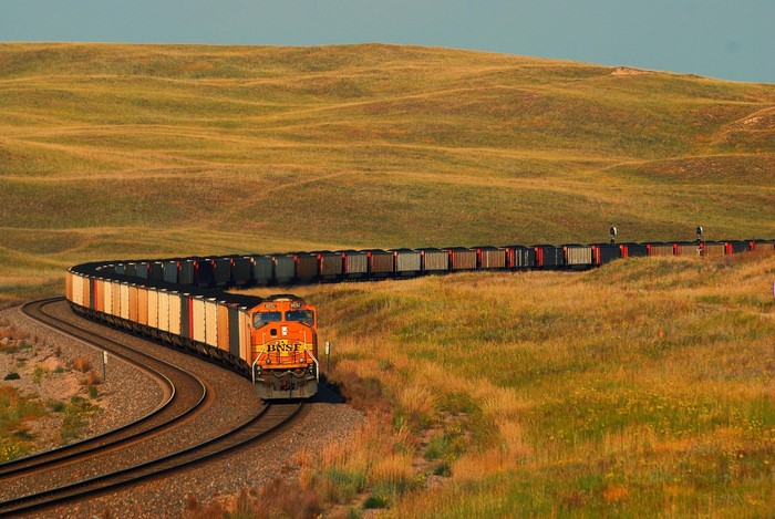 BNSF Train on Railroad Tracks in Grassy Hills