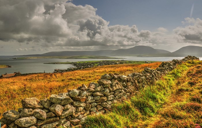 Stone wall overlooking a bay with distant hills