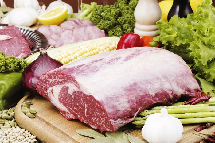 Raw beef roast with fresh vegetables and spices