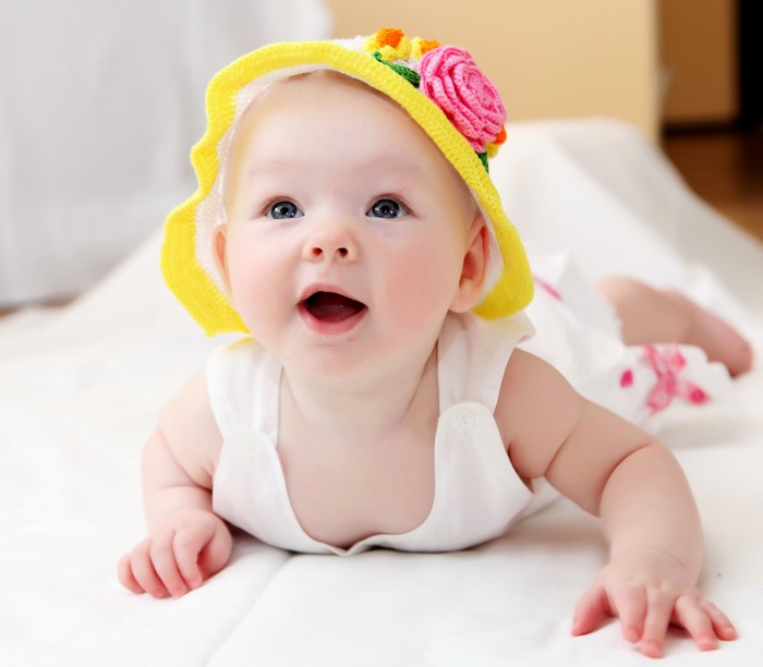 Baby wearing a yellow hat with flowers