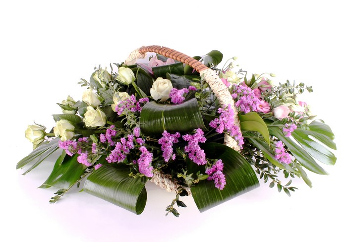 Bouquet of white roses and purple flowers in a basket