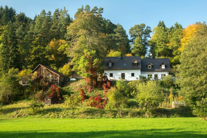 White house and barn in a forest in Bavaria, Germany