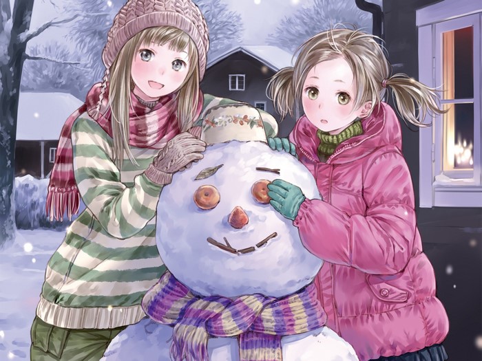 Two girls building a snowman in the snow