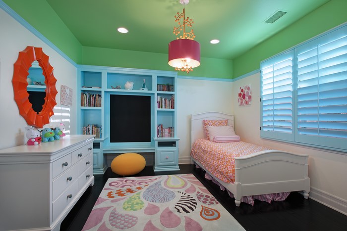 Children's Bedroom with Blue Built-in Shelving and Orange Mirror