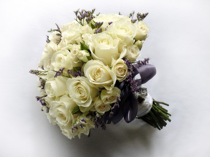 White rose bouquet with purple accents and ribbon
