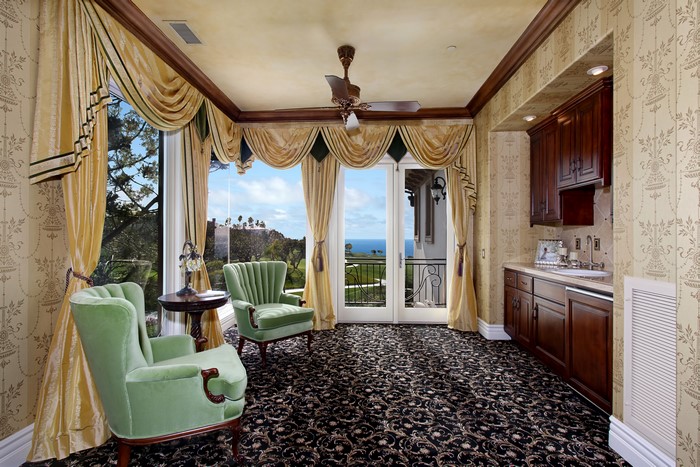 Living room with ornate curtains and ocean view