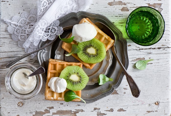 Waffles with kiwi and cream on a plate