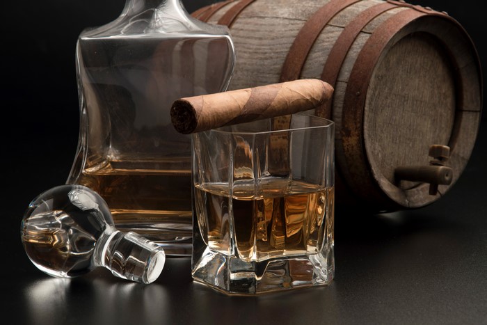 Whiskey decanter, glass, cigar, and barrel