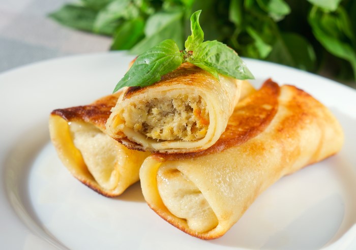 Rolled pancakes with filling and basil