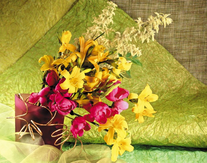 Bouquet of yellow lilies and pink tulips in a vase