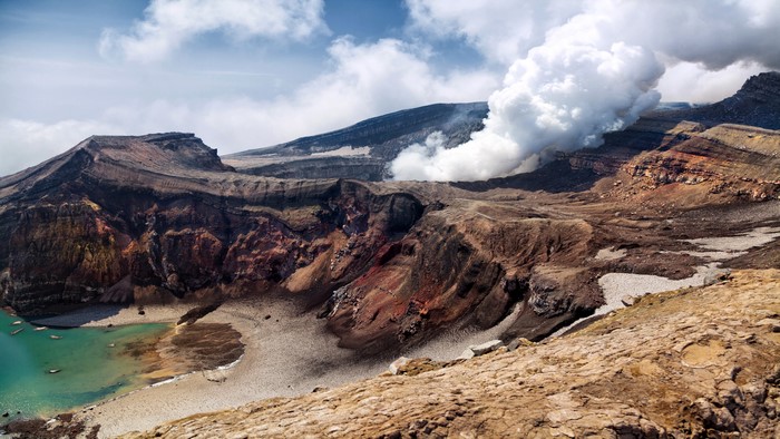 Volcano crater with steam on Kamchatka Peninsula, Russia