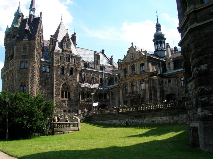 Moszna Castle in Poland with a green lawn