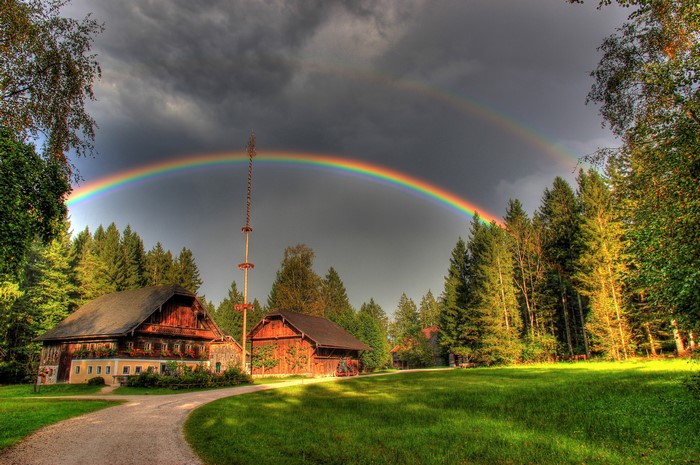 Rainbow over houses and trees in Grossgmain, Austria