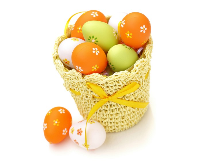 Easter eggs in a wicker basket with a yellow ribbon