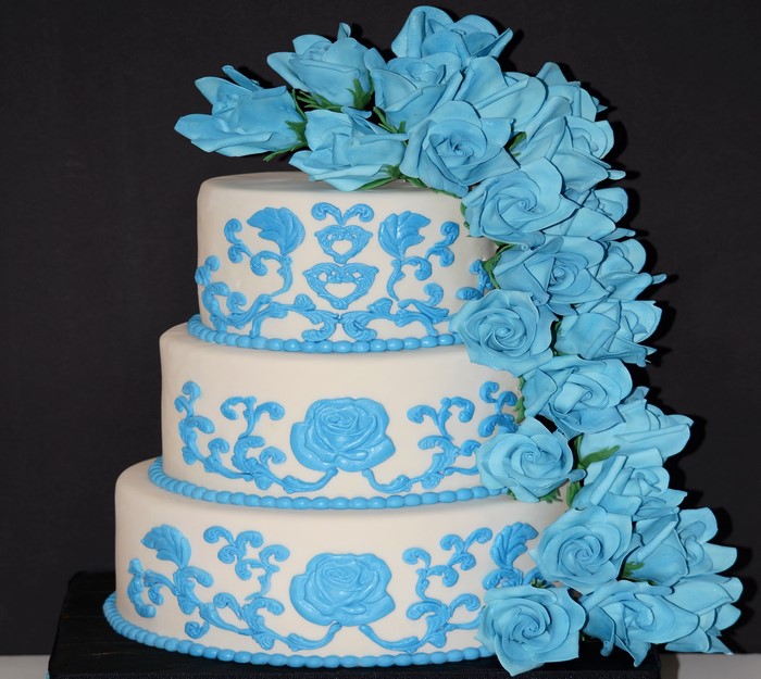 Three-tier white cake with blue rose decorations