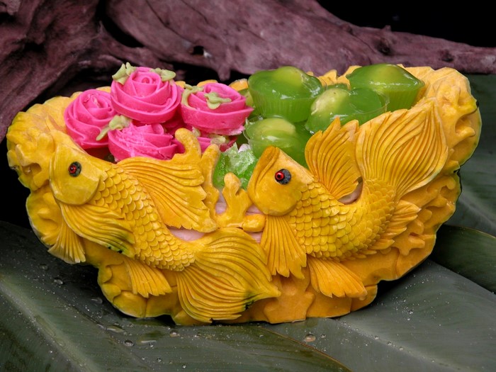 Yellow fish carved dessert with pink roses and green jelly