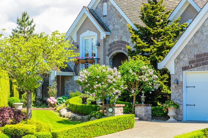 Stone house with manicured garden and driveway