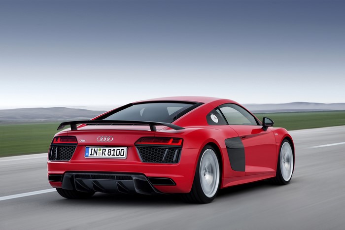Red Audi R8 V10 plus driving on a road