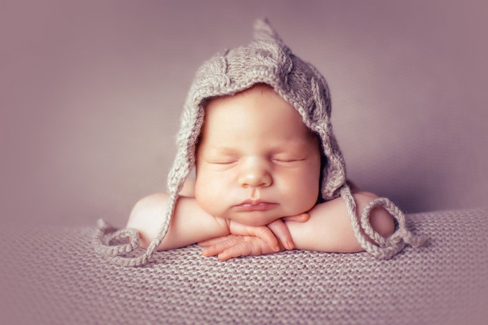 Newborn baby sleeping in a knitted winter hat