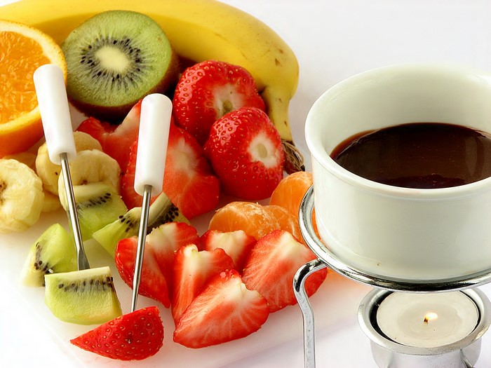 Fruit fondue with chocolate and candle