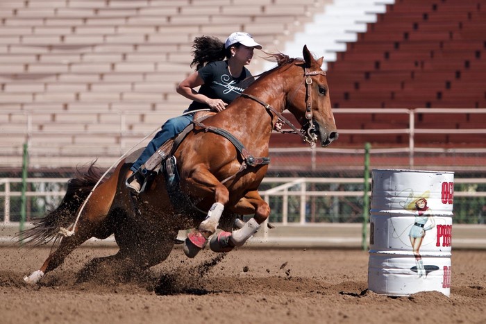 Woman barrel racing on a horse