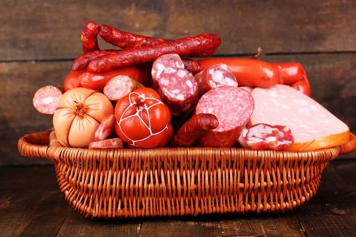 Meat products and sausages in a wicker basket