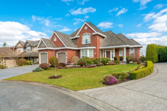 Brick Mansion with Manicured Lawn and Driveway