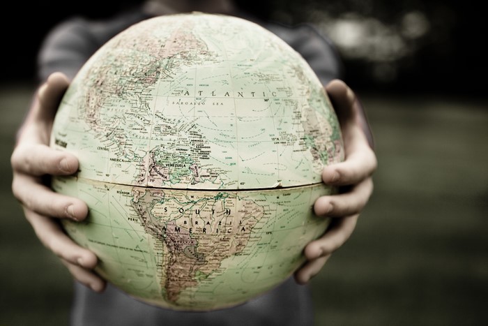 Hands holding a globe showing Earth