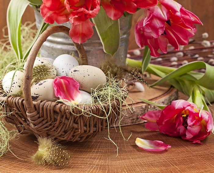 Easter eggs in a wicker basket with tulips
