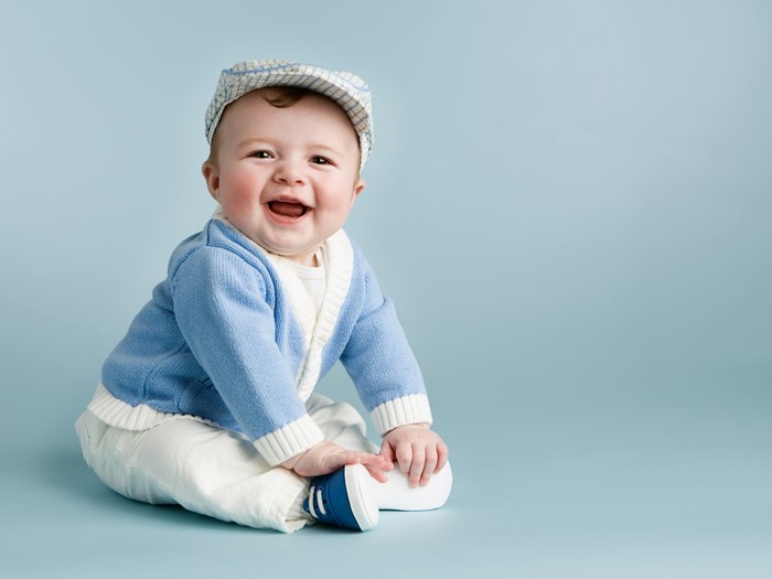 Baby boy in blue sweater and cap smiling