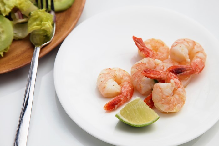 Shrimp on a plate with lime and salad