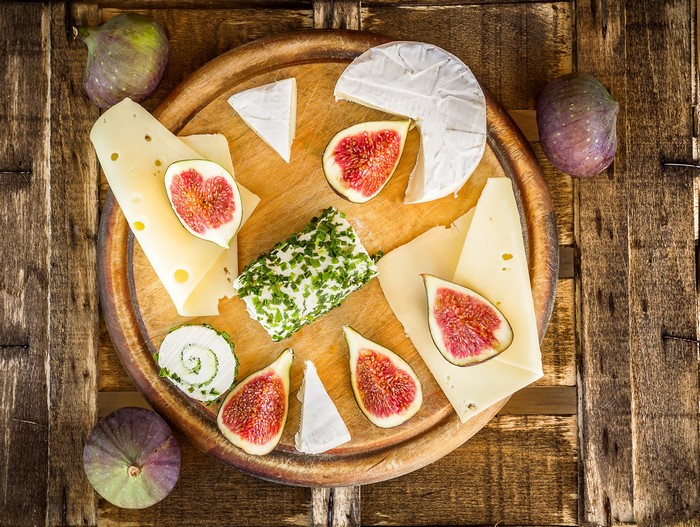 Cheese and figs on a wooden board