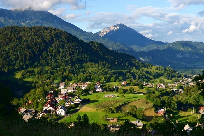 Village nestled in a valley with mountains and forests in Slovenia