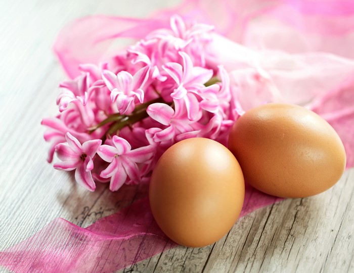 Easter eggs and pink hyacinths on a wooden surface