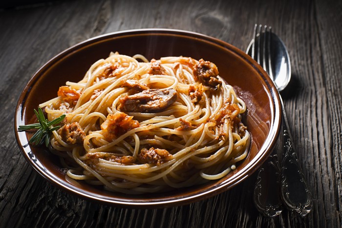 Spaghetti with meat sauce and rosemary in a bowl