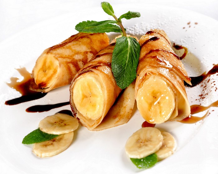 Banana crepes with chocolate syrup and mint