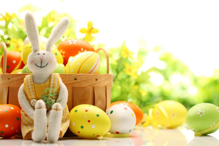 Easter bunny with decorated eggs in a wicker basket