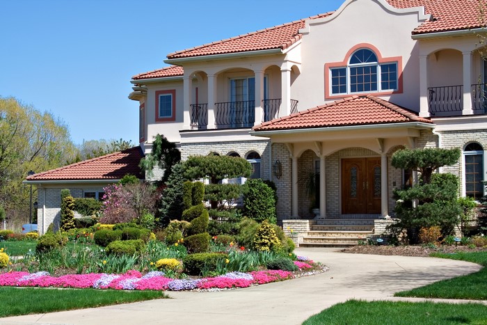 Mansion with manicured garden and red tile roof