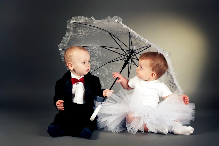 Two babies under an umbrella